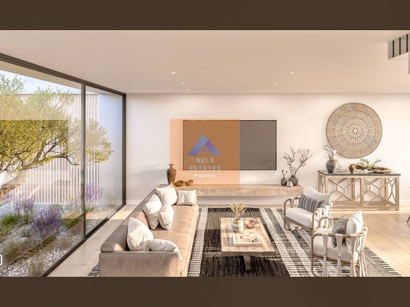 Modern open-plan living area featuring floor-to-ceiling glass walls overlooking a private courtyard, recessed lighting, and sleek floating cabinetry.