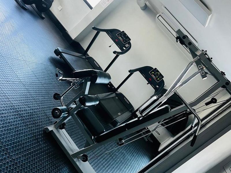 A well-maintained apartment gym facility featuring durable rubber flooring, climate control, and integrated lighting.