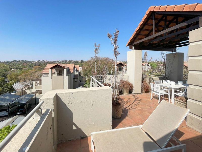 Spacious rooftop balcony featuring tiled flooring, a covered pergola, and panoramic views of the surrounding estate.