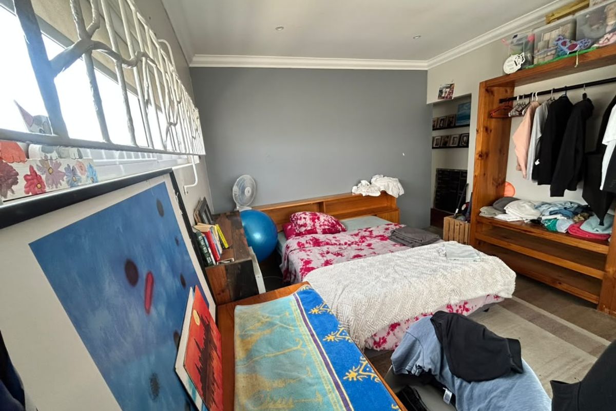 A functional bedroom featuring recessed downlighting, coving, and a built-in headboard, offering a practical layout with security bars on the window.