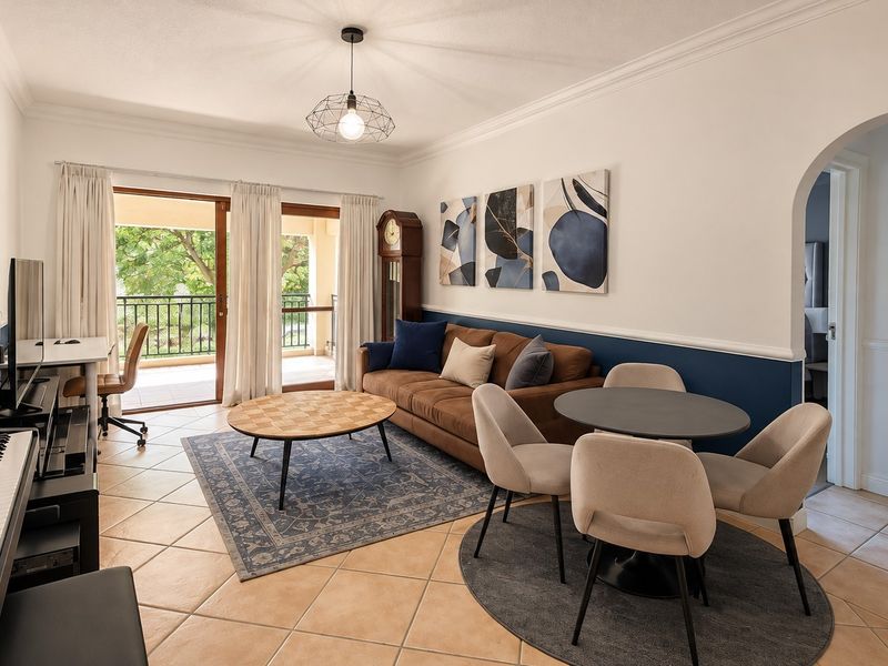 Spacious open-plan living and dining area featuring tiled flooring, elegant wainscoting, and large sliding doors leading to a private balcony.