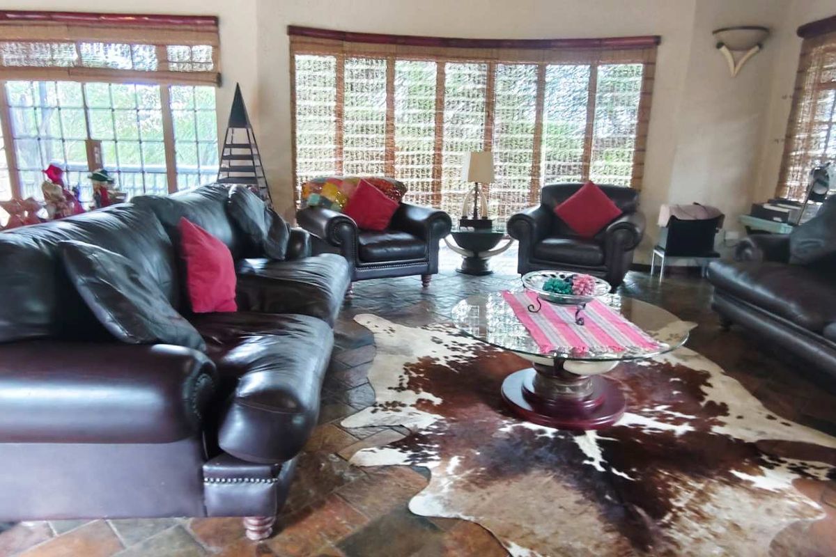 Spacious living room featuring terracotta tile flooring and large windows that provide ample natural light, creating a warm and inviting atmosphere.