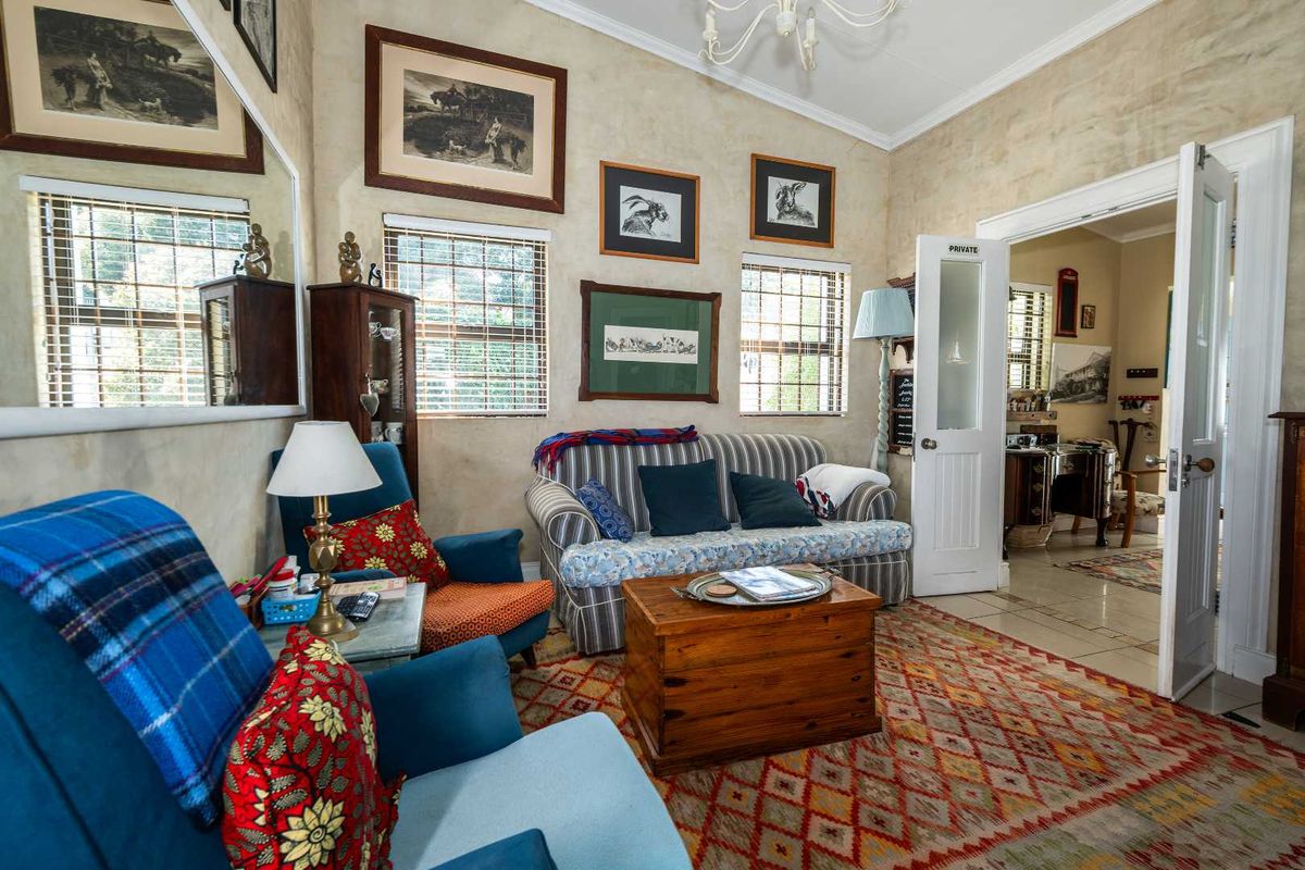 A cozy living room featuring textured wall finishes, classic french doors, and natural light through venetian blinds.