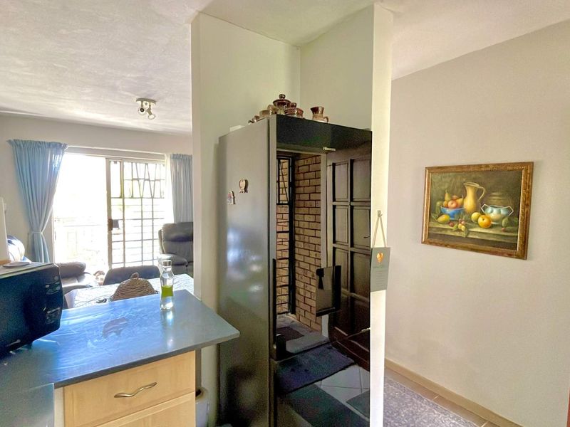 Open plan living area featuring a kitchen counter, brick feature wall, and sliding door access to the exterior.