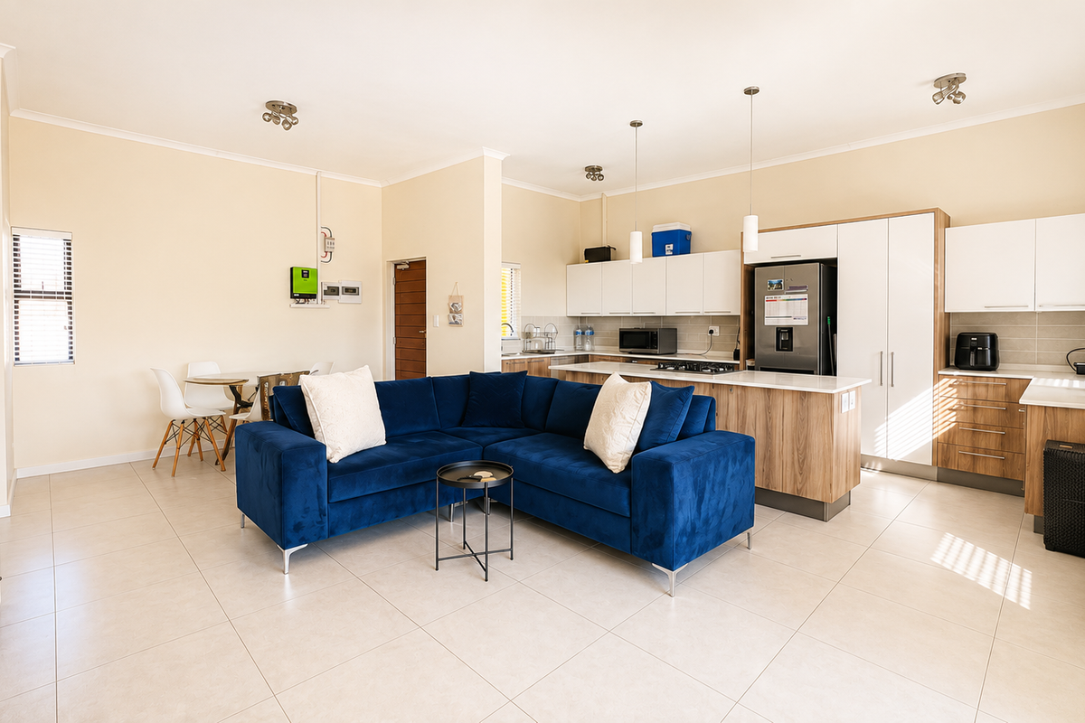 Spacious open-plan living area featuring a modern kitchen with built-in cabinetry, a central island, and tiled flooring throughout.