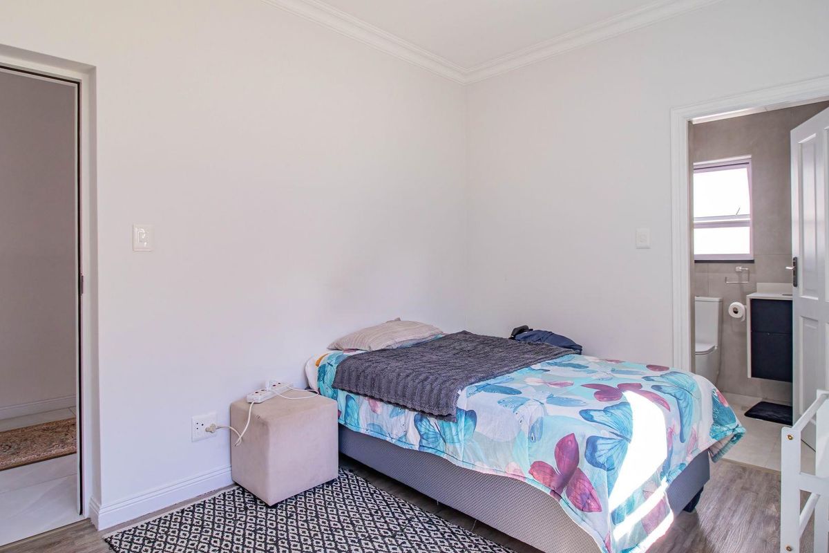 A well-maintained bedroom featuring neutral walls, coving, and direct access to an en-suite bathroom.