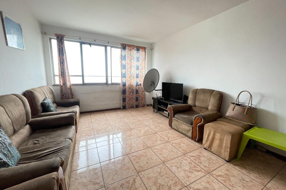 A living room featuring tiled flooring and a large window, offering a blank canvas for potential renovation and modernization.