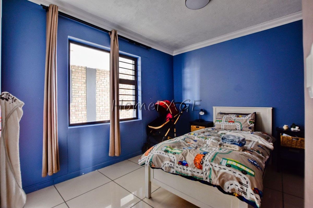 A bedroom featuring tiled flooring, security bars on the window, and decorative cornice detailing.