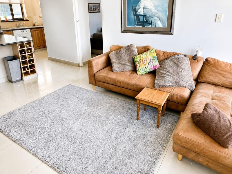 Open plan living area featuring tiled flooring and a functional kitchen with built-in cabinetry and a wine rack.