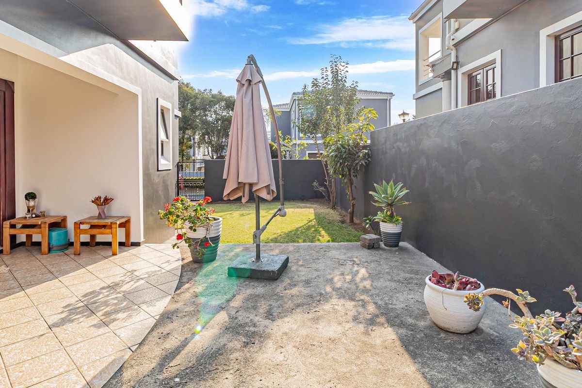 A private rear courtyard featuring a tiled patio area, concrete slab, and enclosed boundary walls, offering a low-maintenance outdoor space.