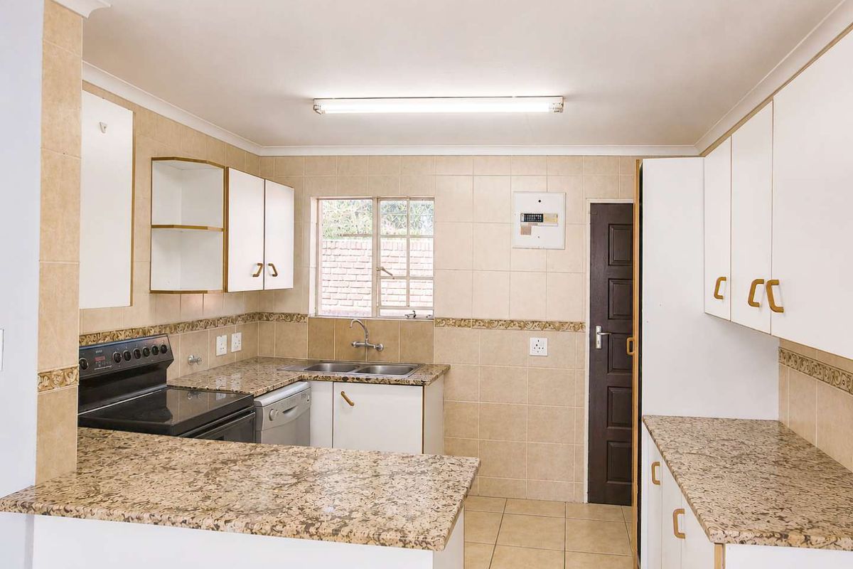 A functional kitchen featuring granite countertops, tiled backsplash, and ample built-in cabinetry, offering a clean and practical layout for daily use.