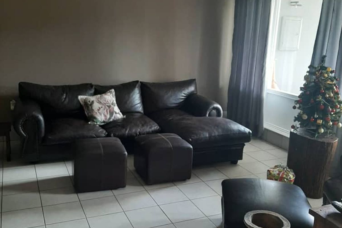 A living room featuring tiled flooring and a beadboard ceiling, providing a neutral base for the living space.