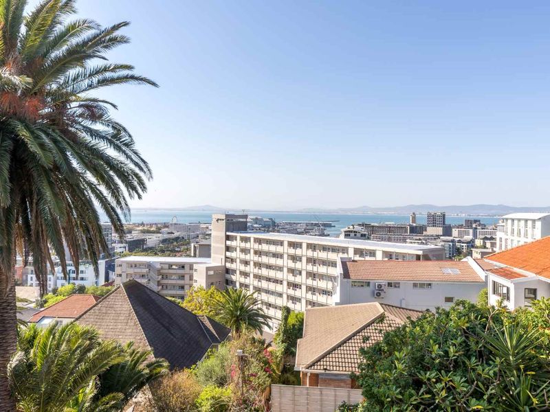 An elevated panoramic view overlooking the city skyline, harbour, and distant coastline, showcasing the property's prime location and scenic outlook.