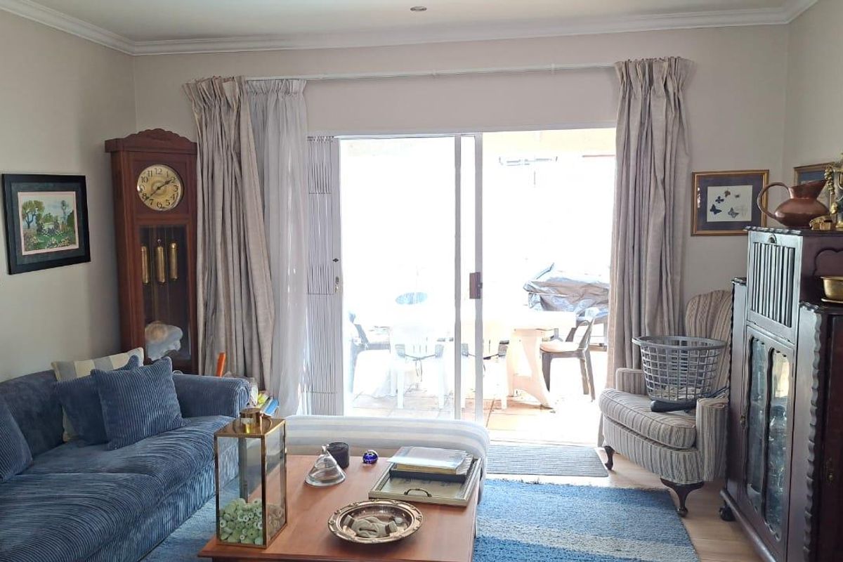 A comfortable living room featuring sliding glass doors that provide direct access to an outdoor patio area, allowing for natural light and indoor-outdoor flow.