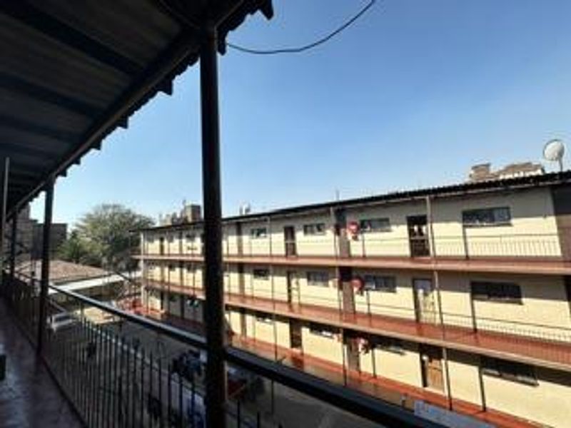 A view from an elevated balcony overlooking the apartment complex courtyard and adjacent building facade.
