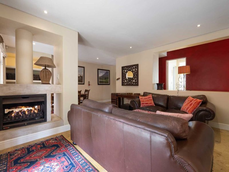 Spacious living room featuring a built-in fireplace with stone surround, recessed lighting, and an open-plan layout connecting to adjacent living areas.