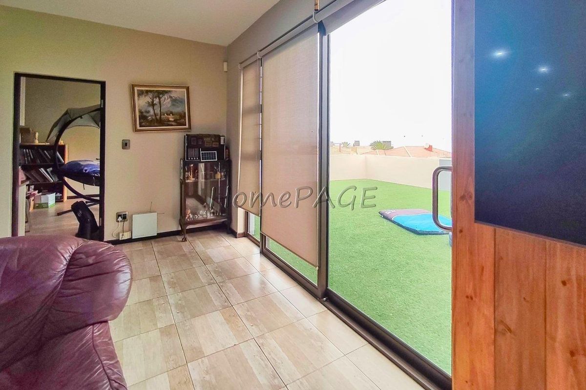 Living area featuring large sliding glass doors that open onto an outdoor patio space with artificial turf.