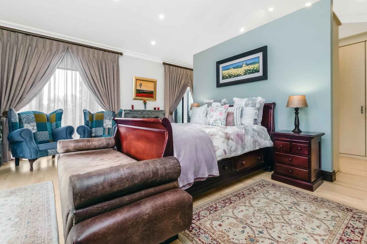 Spacious bedroom featuring light-toned flooring, recessed ceiling lighting, and a feature wall, providing a comfortable and well-maintained living space.