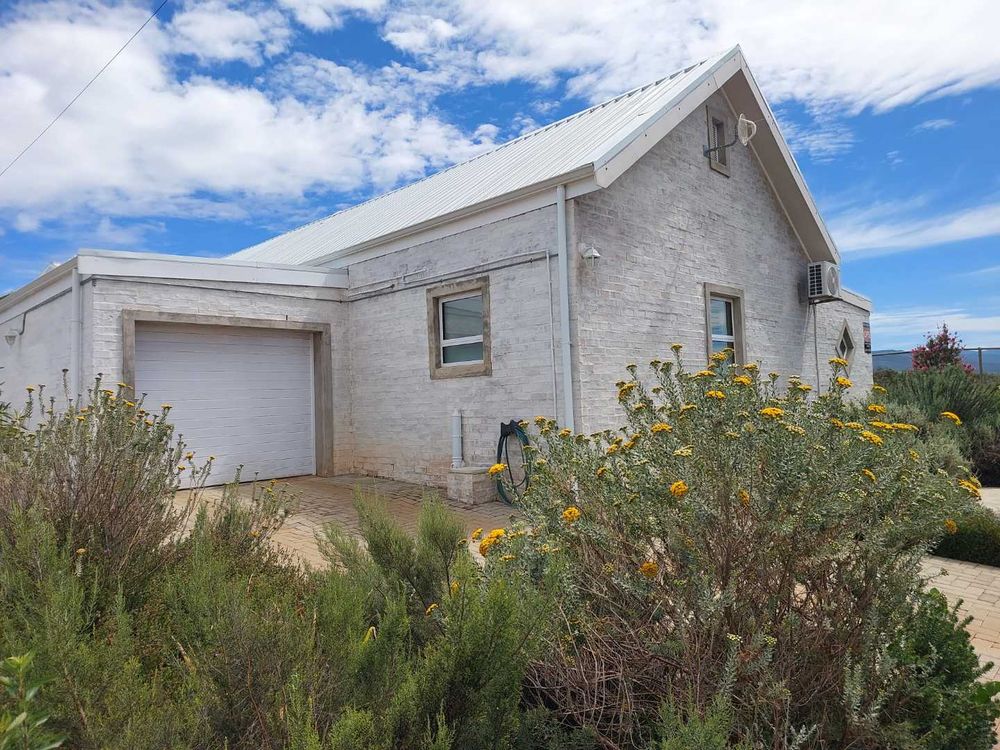 Single garage with automated door and additional parking next to garage