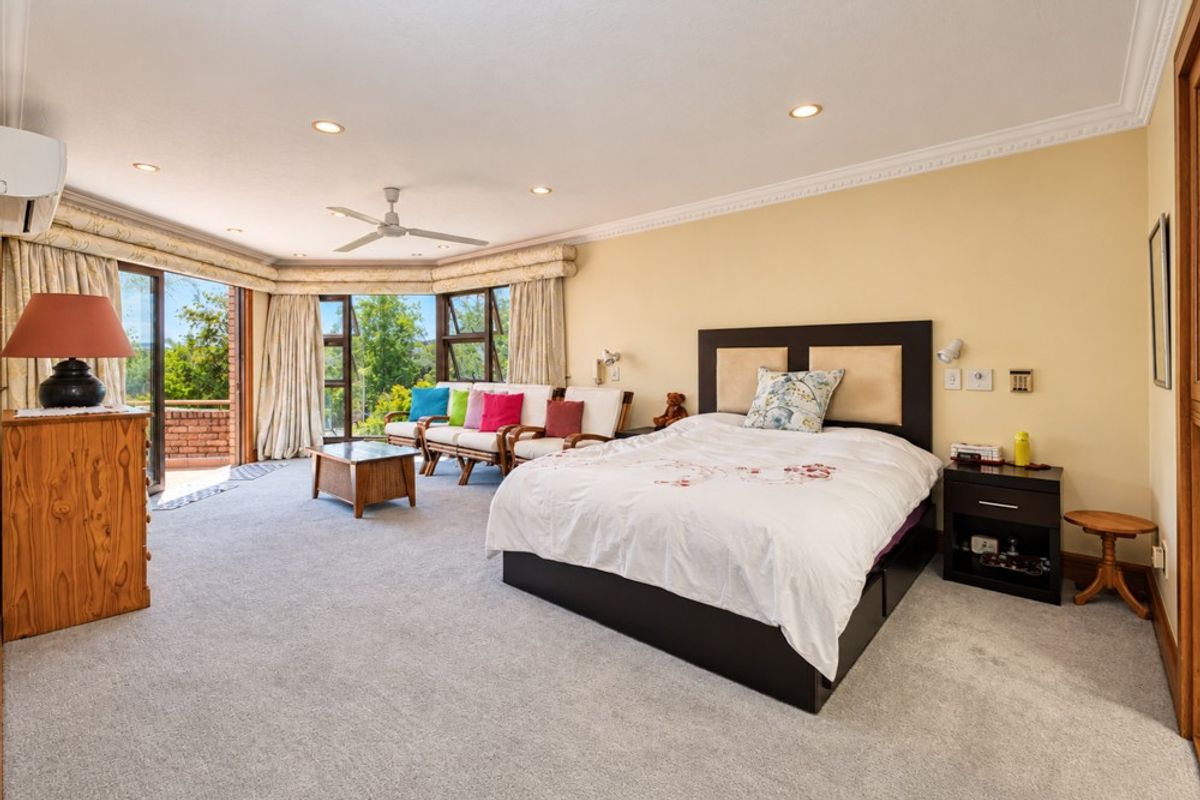 Spacious bedroom featuring crown molding, recessed lighting, a ceiling fan, and large sliding glass doors that open to an outdoor balcony area.