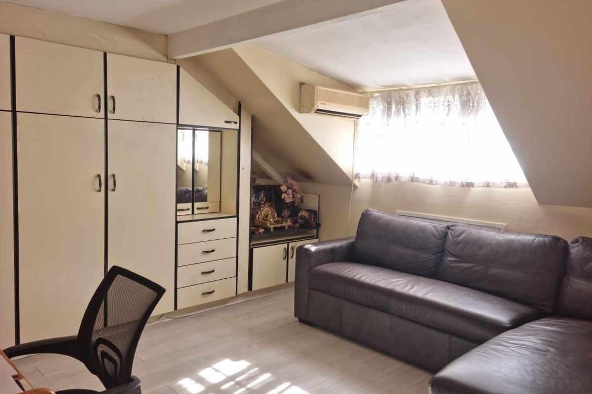 Attic-style bedroom featuring built-in cabinetry, sloped ceilings, and a wall-mounted air conditioning unit.