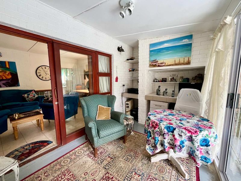 Enclosed patio area featuring painted brick walls, built-in desk workspace, and sliding glass doors providing access to the main living area.
