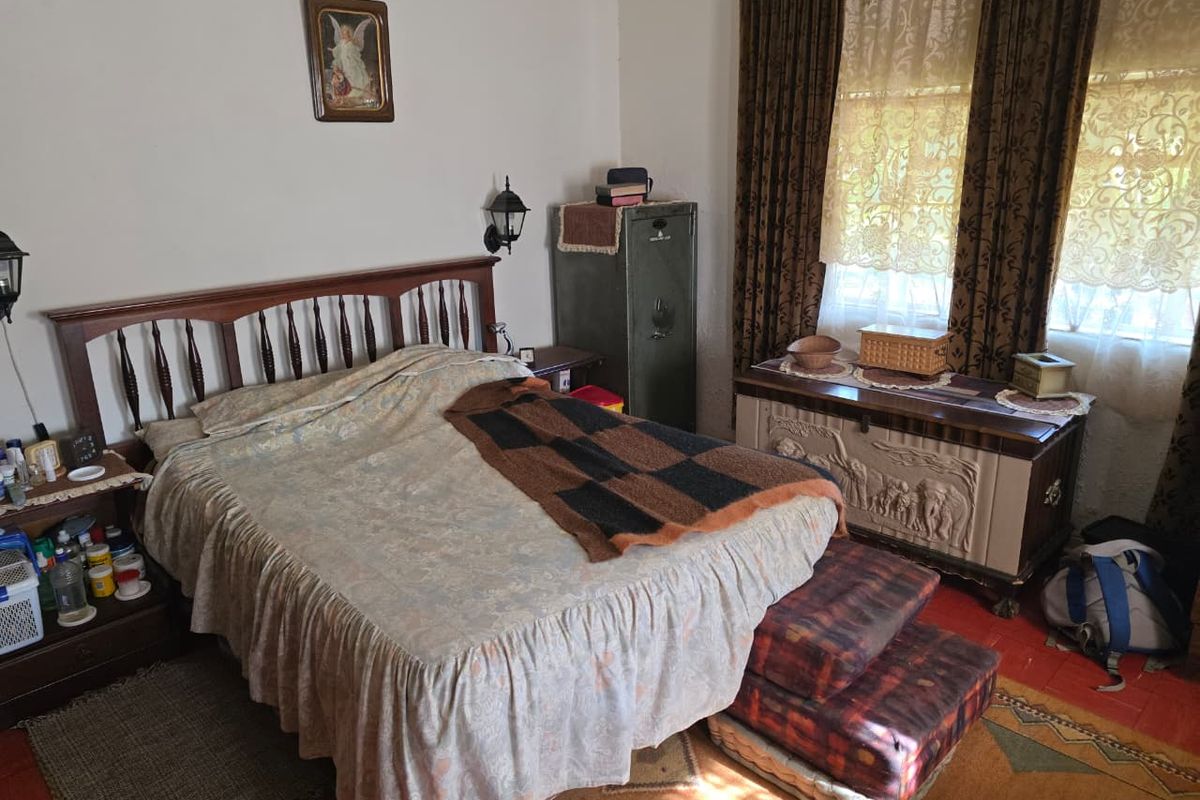 A bedroom featuring tiled flooring and natural light through window treatments.