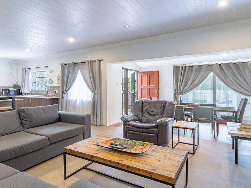 Spacious open-plan living area featuring a modern kitchen with island, tongue and groove ceiling, and seamless flow to the dining and lounge spaces.