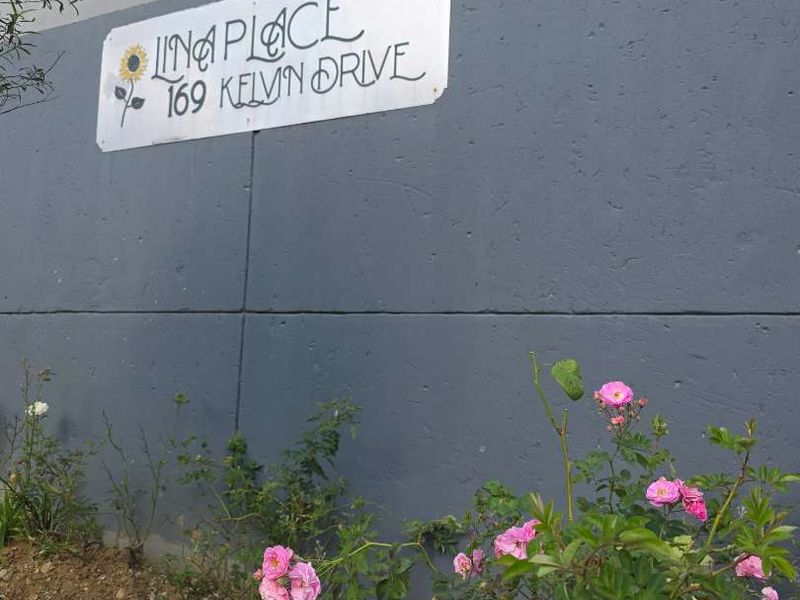 Exterior view of the property boundary wall featuring electric fencing and the address signage for Lina Place at 169 Kelvin Drive.