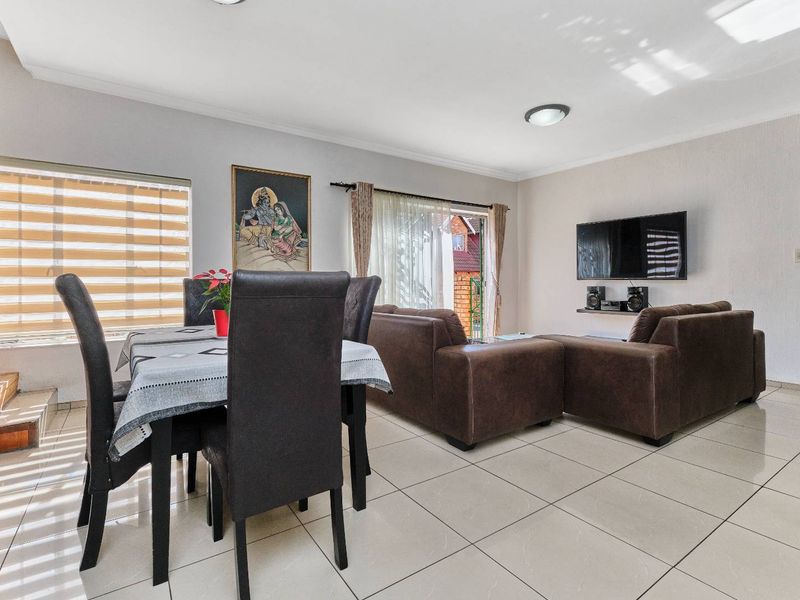 Open plan living and dining area featuring tiled flooring, recessed lighting, and a sliding glass door leading to the exterior.