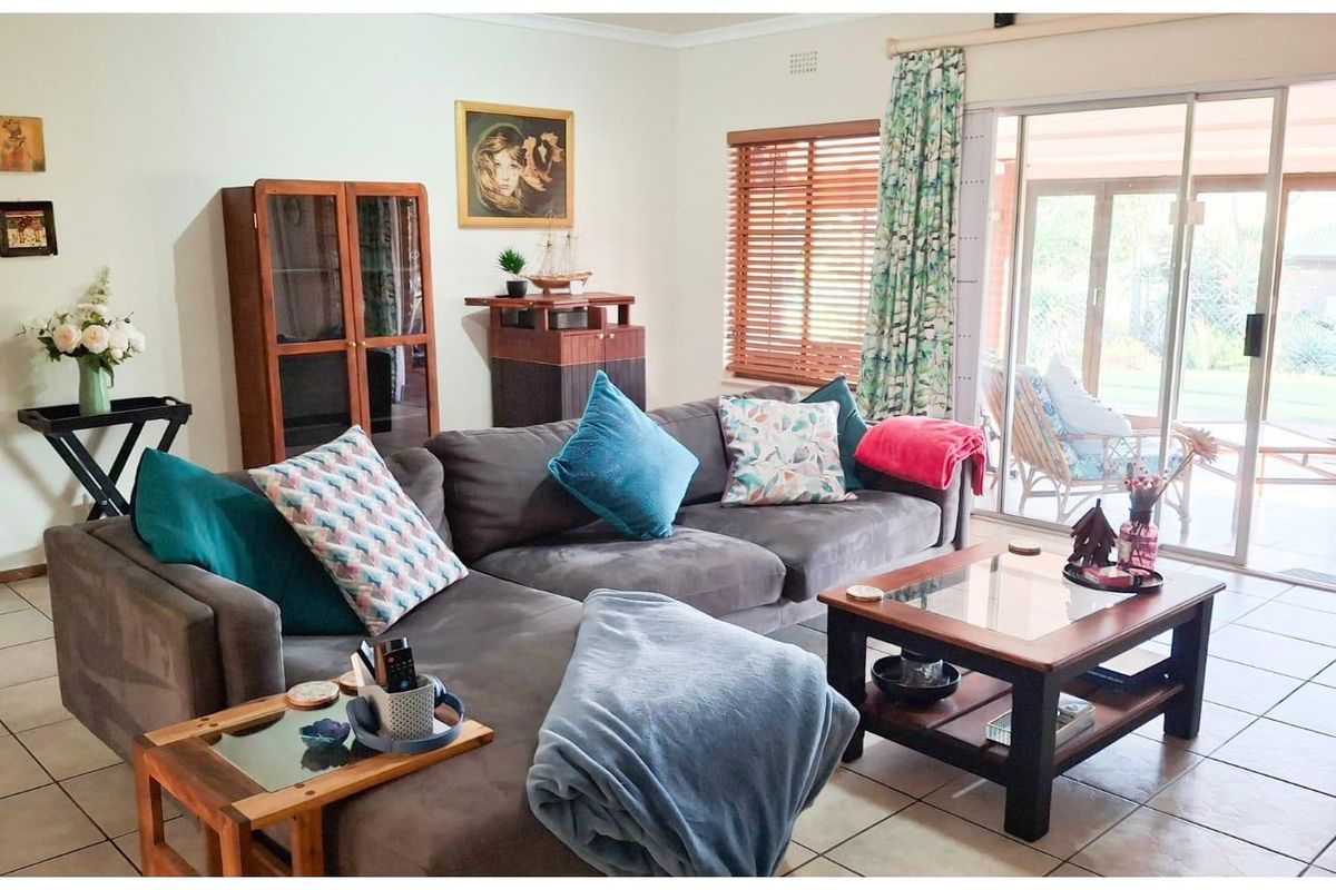 A comfortable living room featuring tiled flooring and large sliding glass doors that provide direct access to the outdoor patio area.