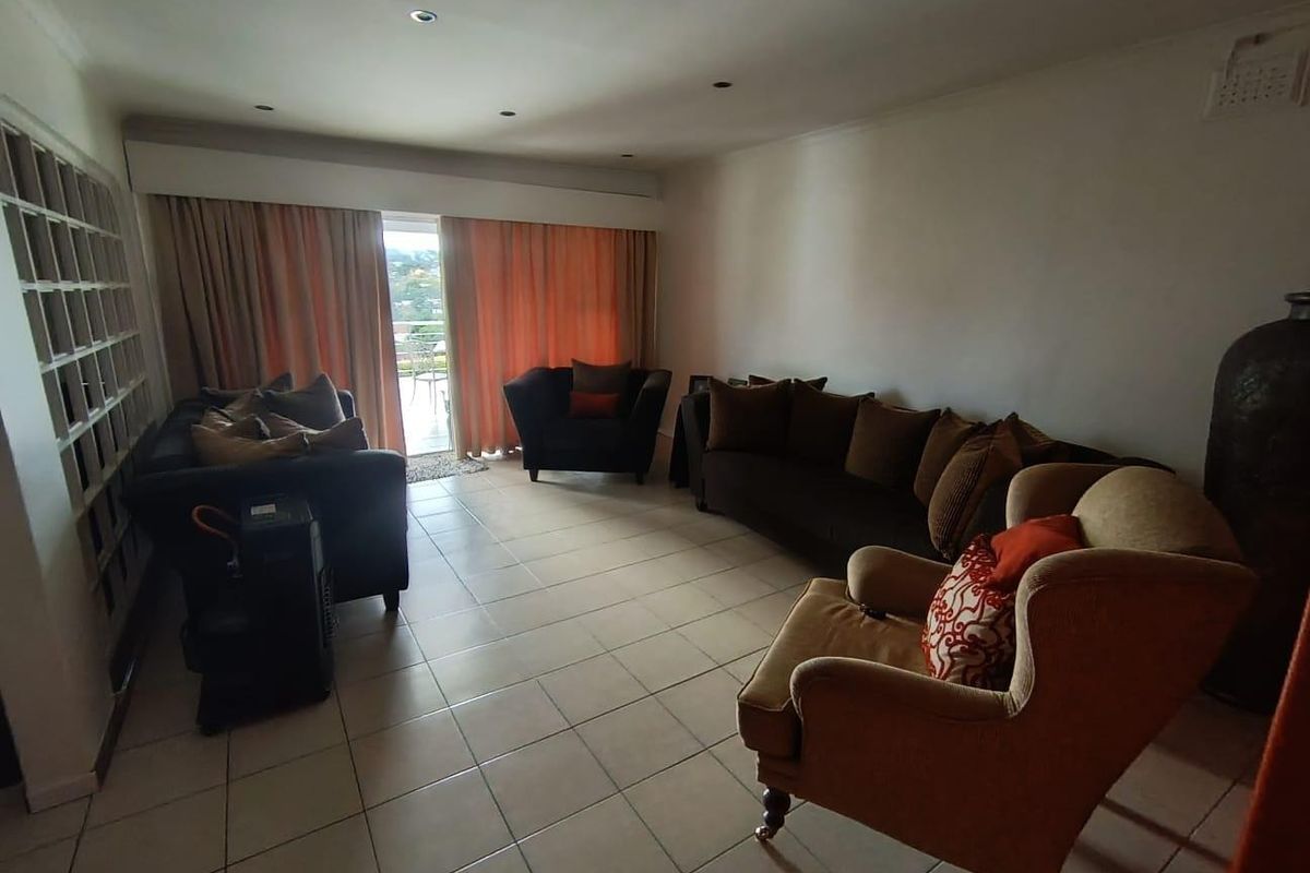 Spacious living room featuring tiled flooring, recessed lighting, and a large sliding glass door providing access to the outdoor area.