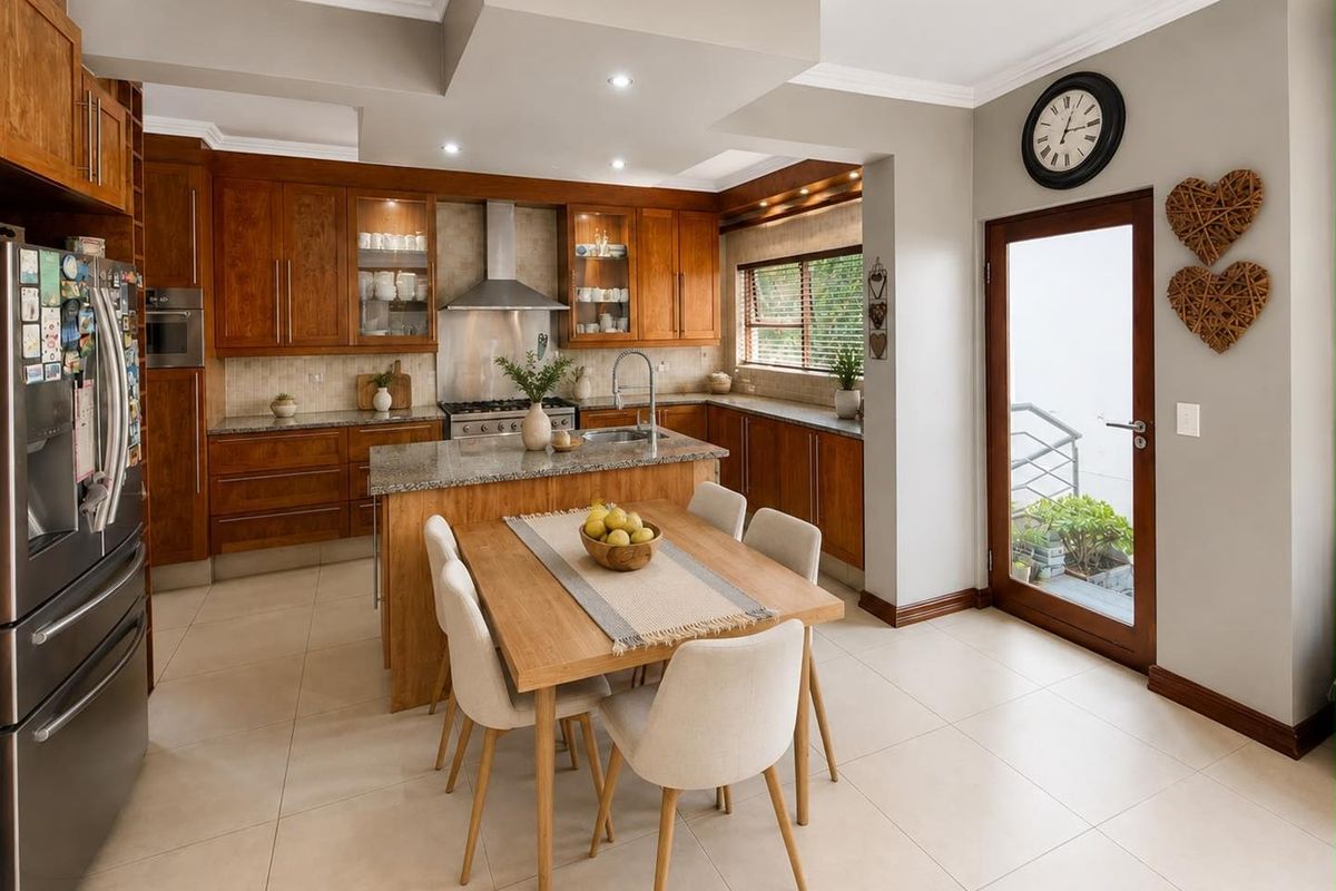 A well-appointed kitchen featuring warm wooden cabinetry, granite countertops, a central island, and direct access to an outdoor area.