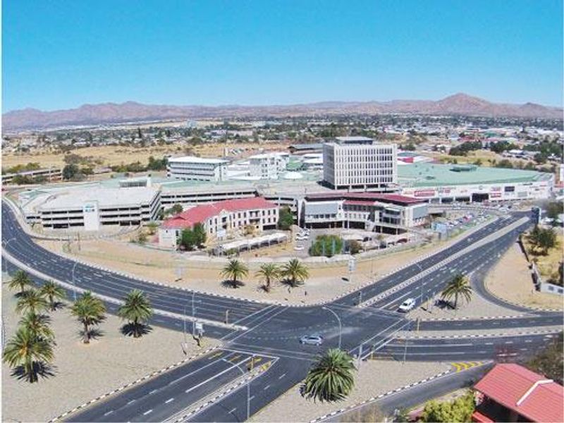 Aerial view of a large commercial office complex and parking facility situated at a major road intersection.