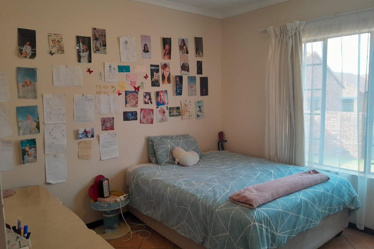 A standard bedroom featuring tiled flooring and a large window that allows for natural light.