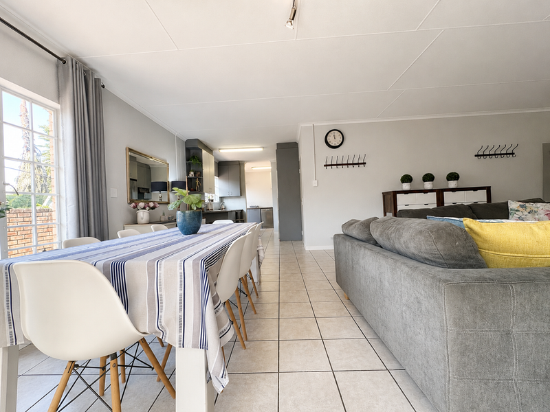 Open-plan living and dining area featuring tiled flooring and direct access to an outdoor patio through a sliding glass door.