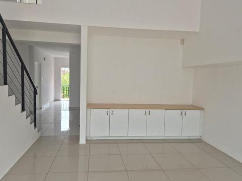 Spacious open-plan living area featuring tiled flooring, a modern staircase with metal balustrade, and built-in storage cabinetry.