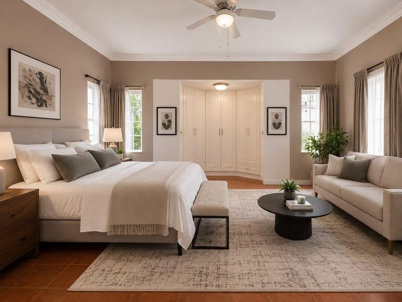 Spacious bedroom featuring built-in cupboards, crown molding, a ceiling fan, and tiled flooring, offering a comfortable and well-maintained living space.