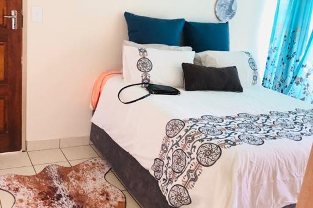 A bedroom featuring tiled flooring and a standard wooden door, providing a functional and neutral living space.