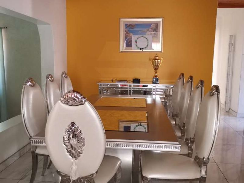 A dining room featuring tiled flooring and a timber tongue and groove ceiling, creating a distinct space for formal meals.
