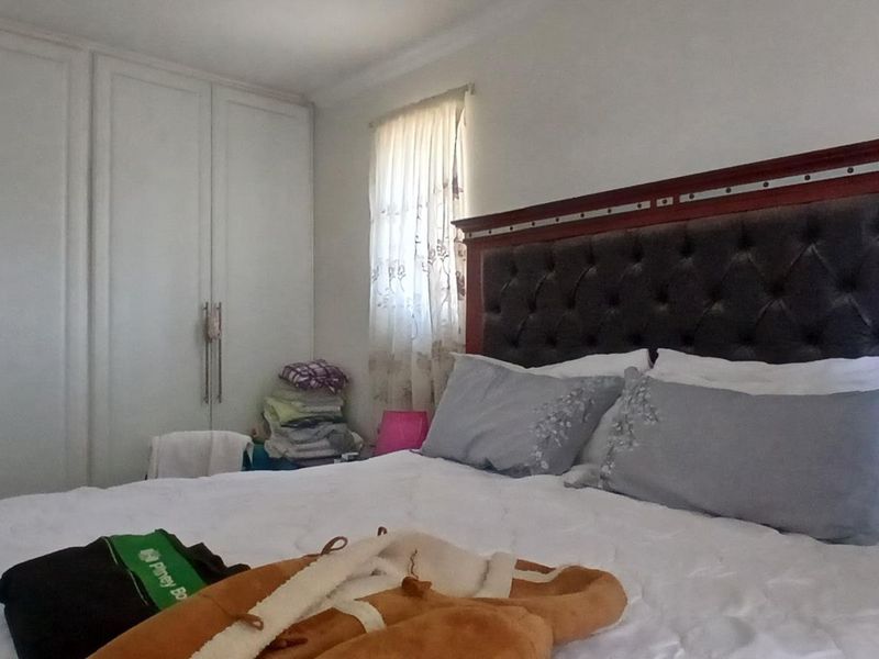 A bedroom featuring built-in cupboards and a neutral interior finish.