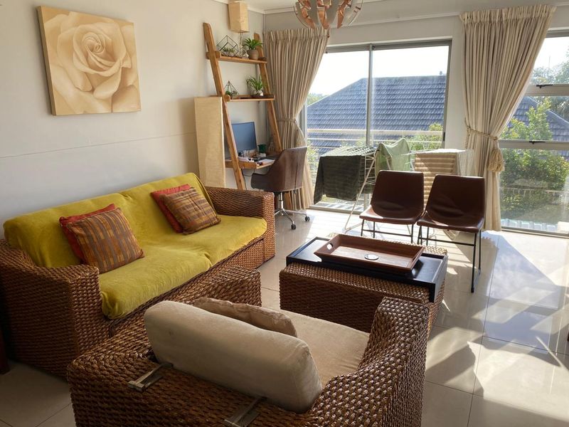 A bright living room featuring large sliding glass doors that provide natural light and access to an outdoor balcony area.