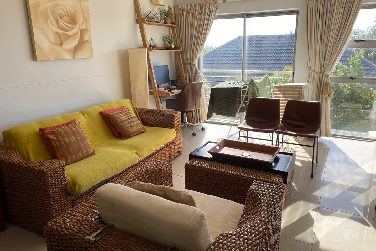 A bright living room featuring large sliding glass doors that provide natural light and access to an outdoor balcony area.