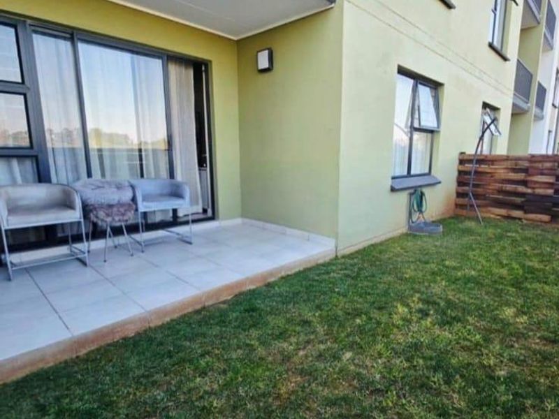 Ground floor patio area with tiled flooring, sliding door access, and a small private garden space with timber screening.