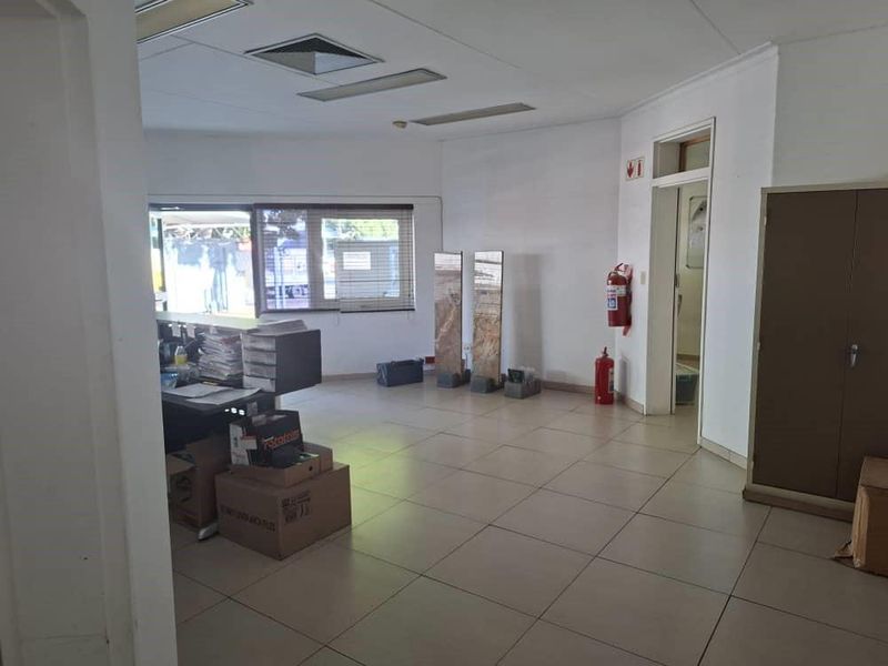 A functional office space featuring ceramic tile flooring, recessed ceiling lighting, and a built-in storage cabinet, suitable for a professional work environment.