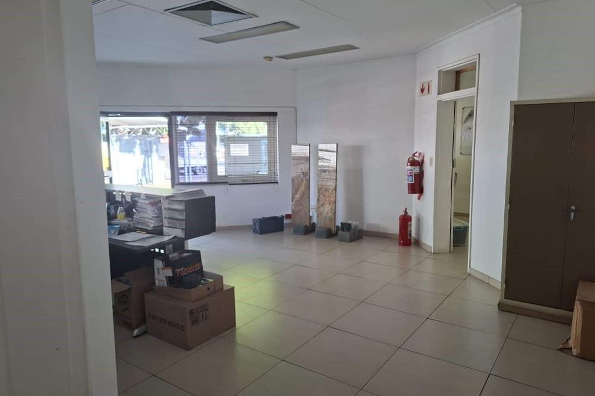 A functional office space featuring ceramic tile flooring, recessed ceiling lighting, and a built-in storage cabinet, suitable for a professional work environment.