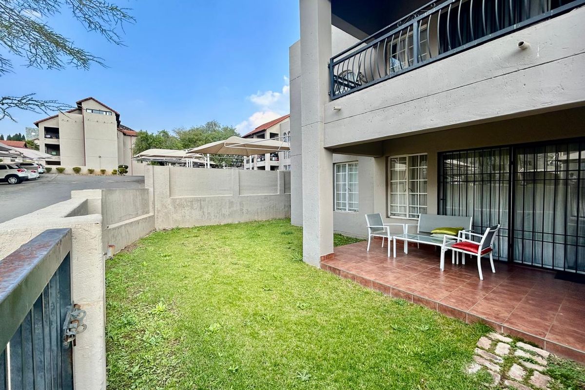 Ground floor apartment featuring a private tiled patio, small garden area, and secure sliding door access with security bars.