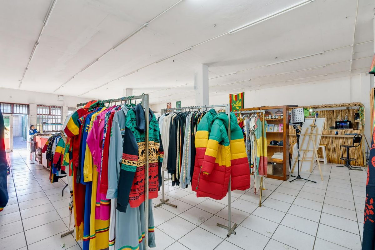 Open-plan retail space featuring white tiled flooring, exposed support columns, and functional strip lighting, suitable for various commercial display layouts.