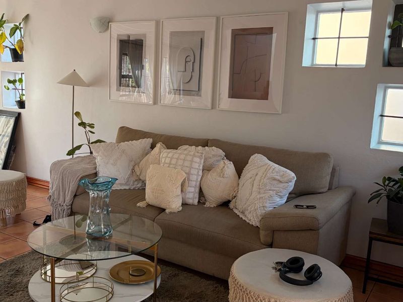 A cozy living room featuring tiled flooring and grid-pattern windows, providing a bright and comfortable space for relaxation.