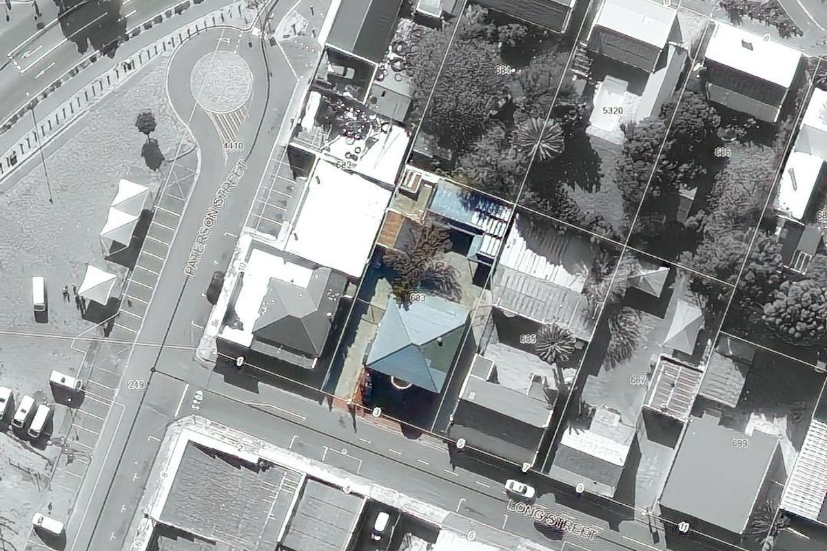 An aerial view showing the property layout, roof structures, and surrounding street network in a mixed-use urban area.
